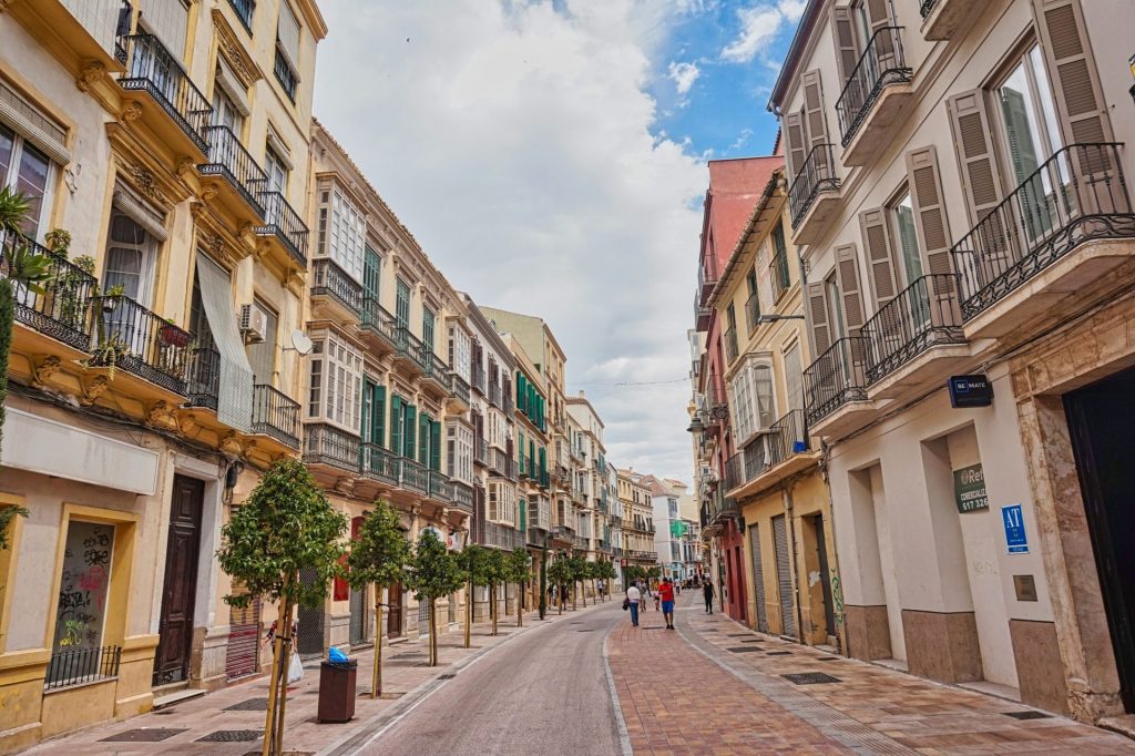 A city street lined with tall buildings with balconies